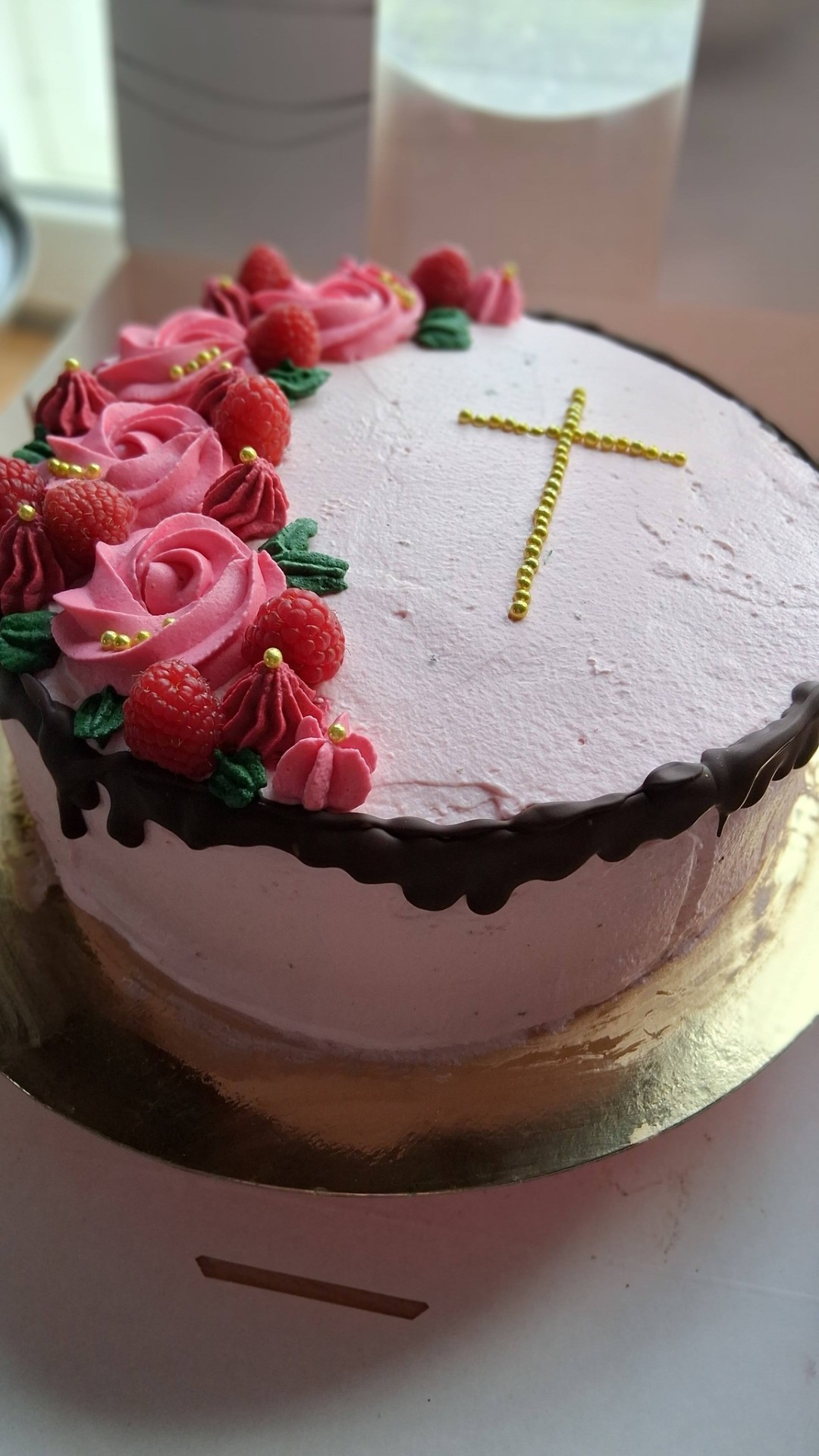 Vaaleanpunainen ristiäiskakku kultaristillä
